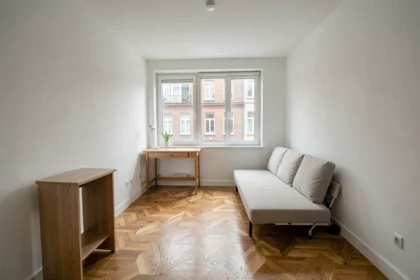 Intérieur d'un studio T1 en copropriété prêt à la vente avec parquet et kitchenette
