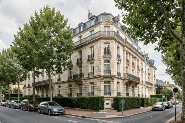 Immeuble de copropriété typique des Yvelines avec façade en pierre et balcons en fer forgé, représentant le marché de la gestion immobilière dans la région